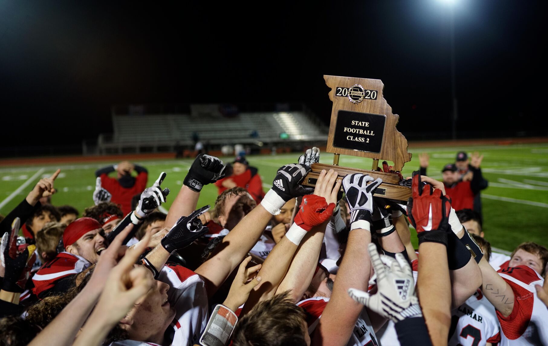 The Lamar Tigers hold up the Class 2 state championship trophy